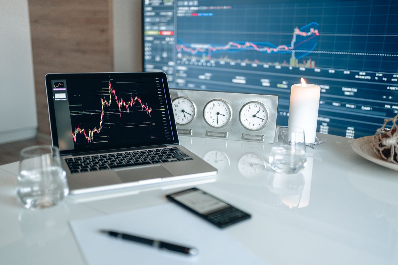 services-03 A modern workspace featuring financial charts and multiple clocks on a white table, ideal for trading.